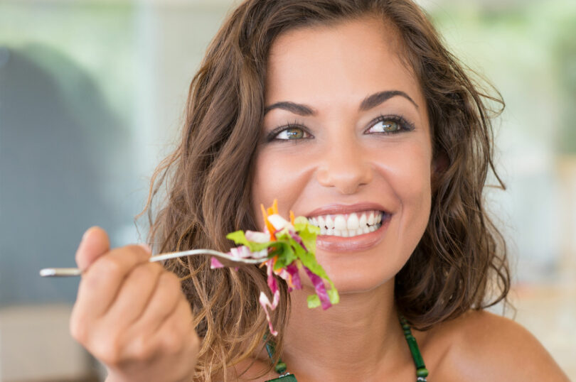 Mulher segurando um garfo com salada