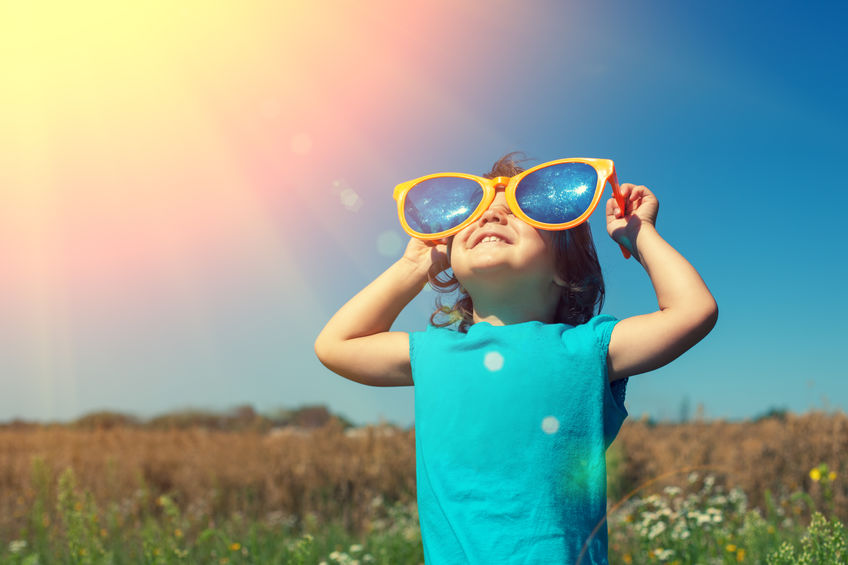 Menina encarando o Sol.