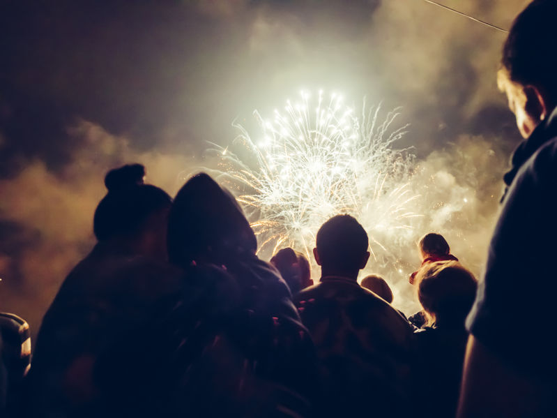 Pessoas olhando queima de fogos.