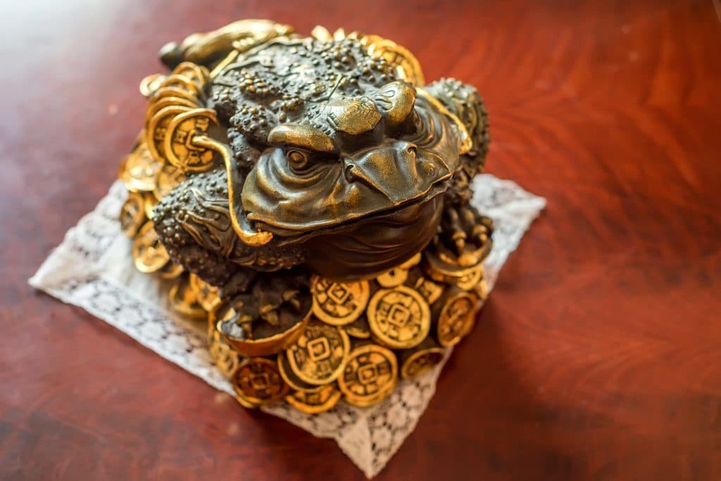 Estátua de sapo de bronze sobre moedas douradas. Trata-se de um souvenir para trazer dinheiro e boas finanças.