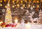 Decoração de Natal toda em miniatura, com árvore iluminada, caixas de presentes, boneco de neve, rena, estrelas e velas.