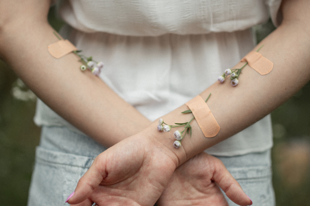 Flores atadas aos braços de uma mulher por curativos.