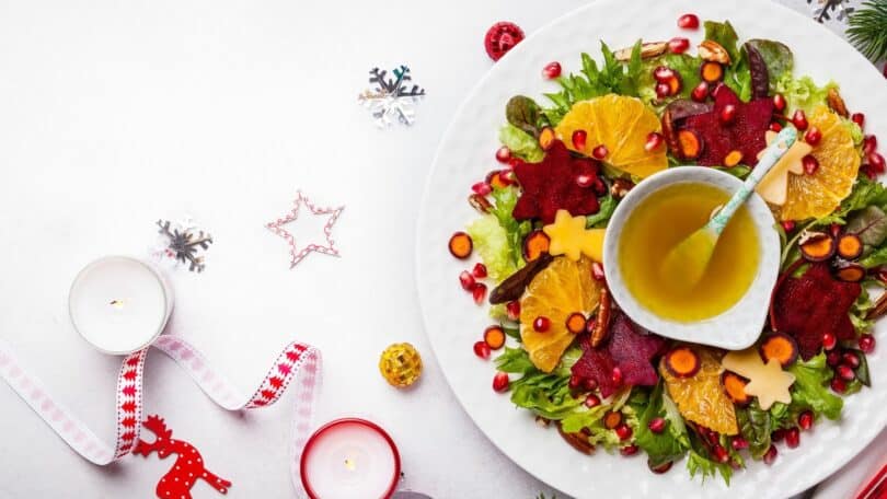 Prato vegano em cima de uma mesa branca com enfeites de natal ao seu redor