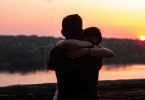 casal abraçado com pôr-do-sol ao fundo