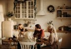 Família sentada ao redor de uma mesa para celebrar a ceia de Natal.