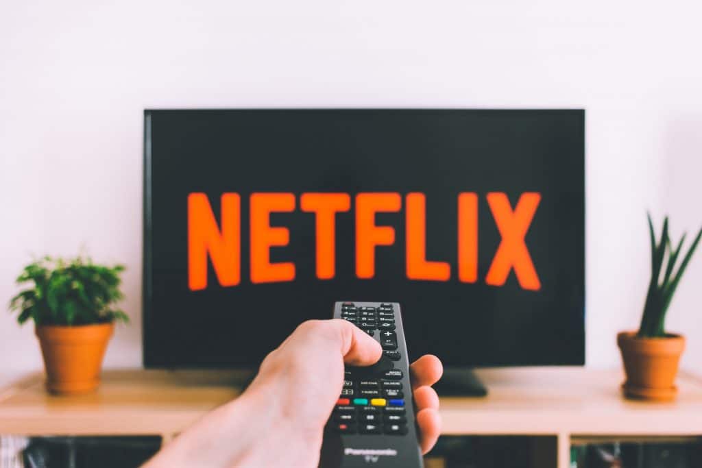Pessoa segurando controle em direção a TV