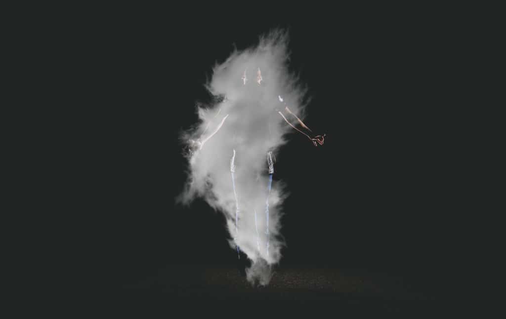 Pessoa levitando envolta por fumaça branca, indicando espiritualidade.