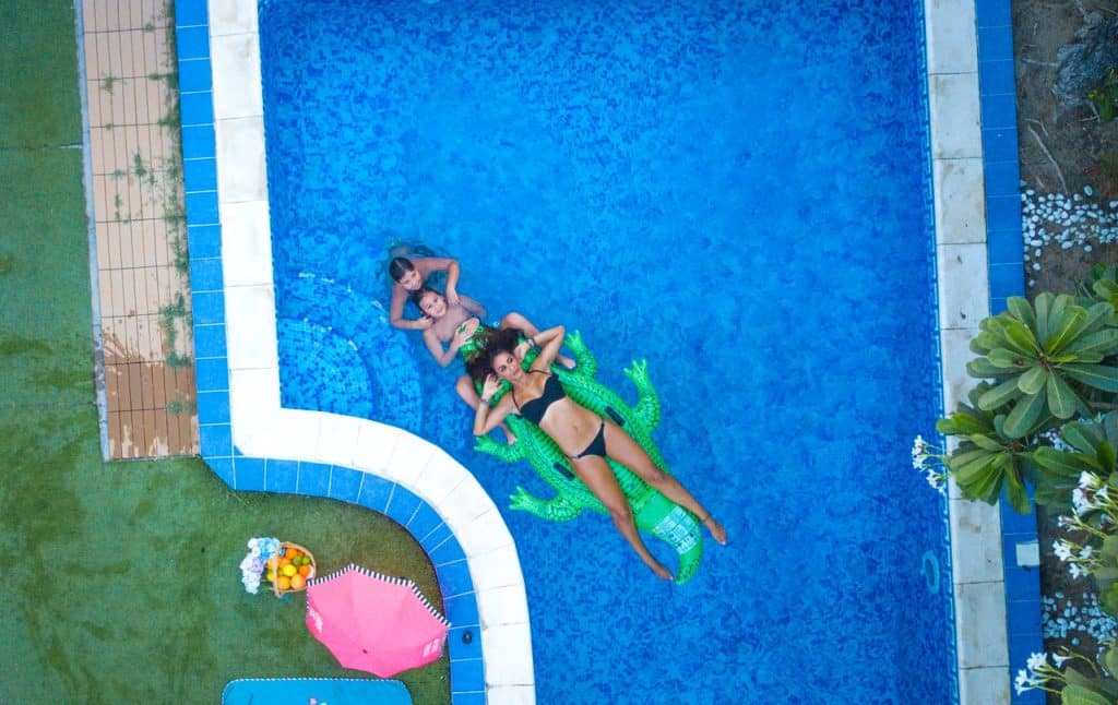 Mulher e duas crianças curtindo piscina.