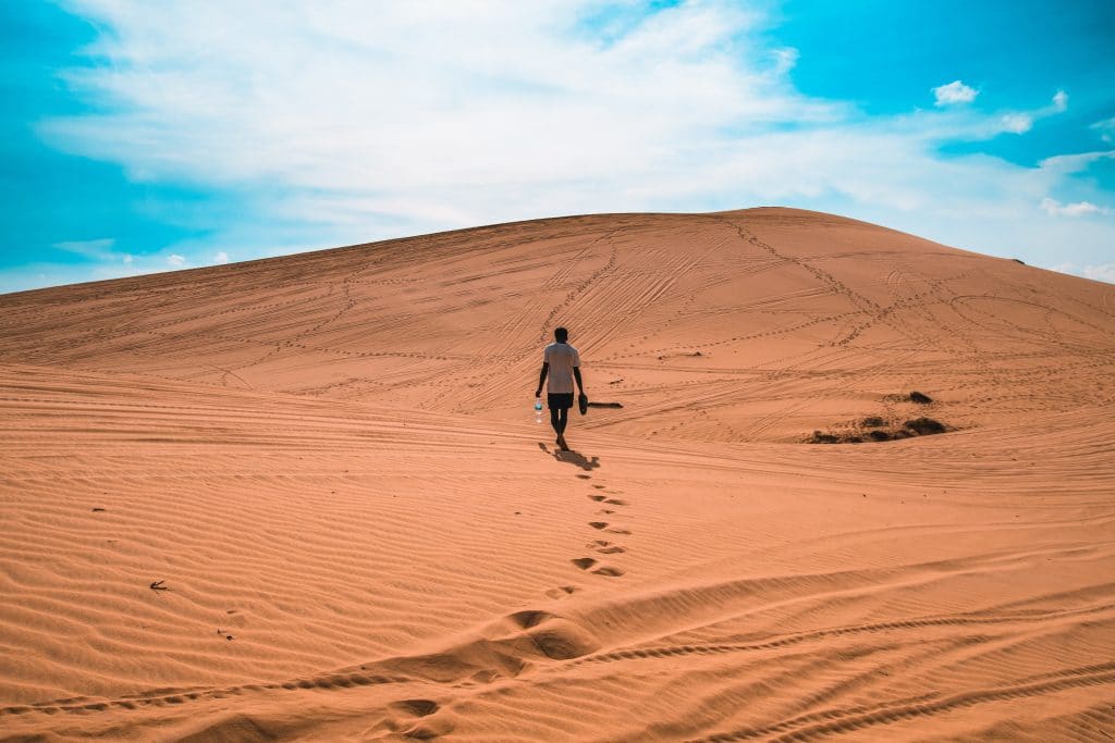 Homem caminhando em deserto 