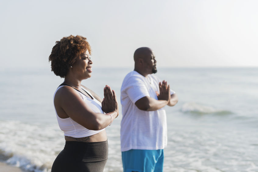 Mulher e homem meditando.