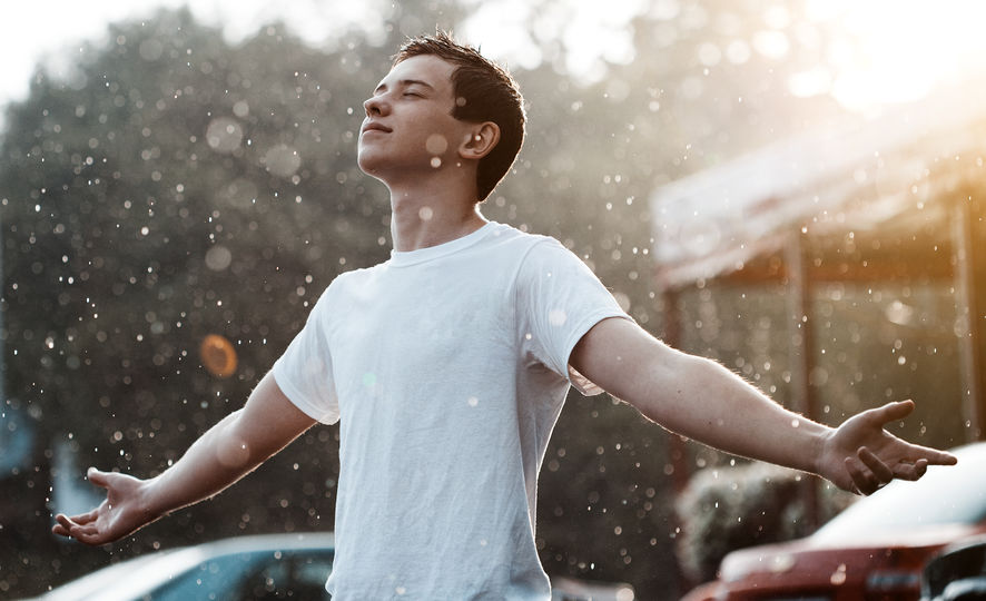 Homem tomando banho de chuva.