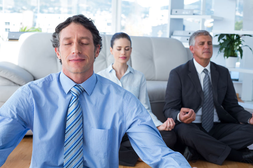 Dois homens e uma mulher meditando.