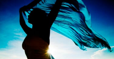 Silhueta de mulher segurando um pano azul.