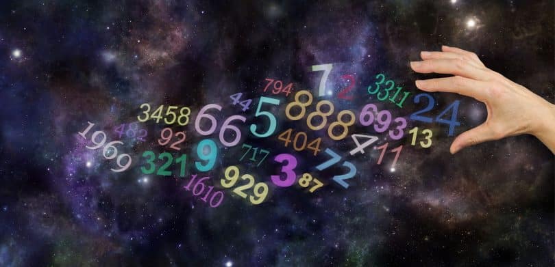Mão feminina em meio a números em cenário de galáxia.