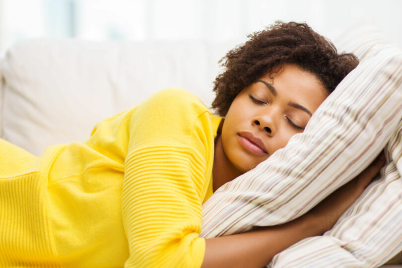 Mulher deitada na cama com os olhos fechados