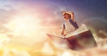 Criança voando no livro