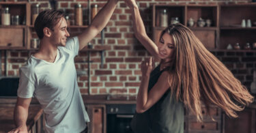 Casal jovem feliz dançando na cozinha