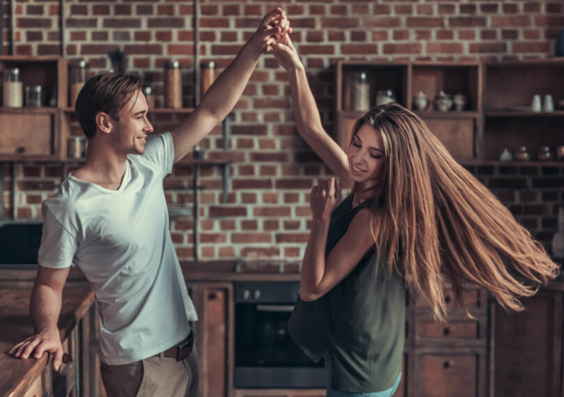 Casal jovem feliz dançando na cozinha