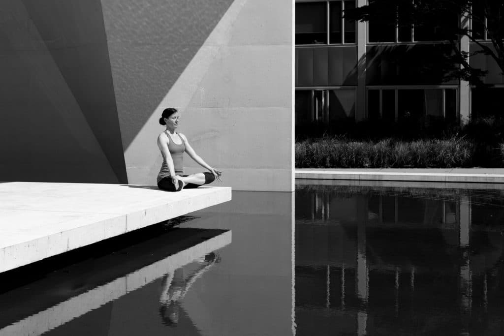 Mulher em posição de meditação  tomando sol em preto e branco