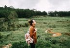 Mulher em paisagem com natureza olhando para cima.