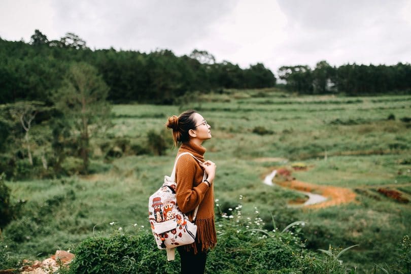 Mulher em paisagem com natureza olhando para cima.