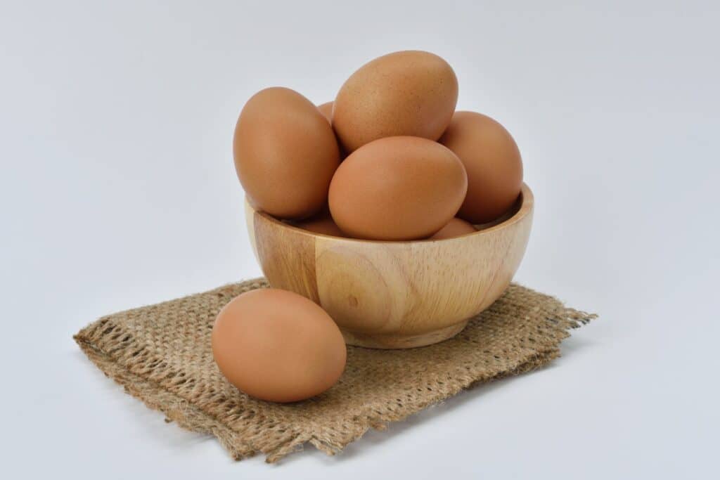 Ovos em uma cesta sobre uma pequena toalha.