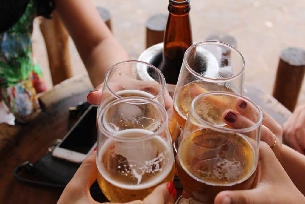 Brinde de copos de cerveja em mesa de bar