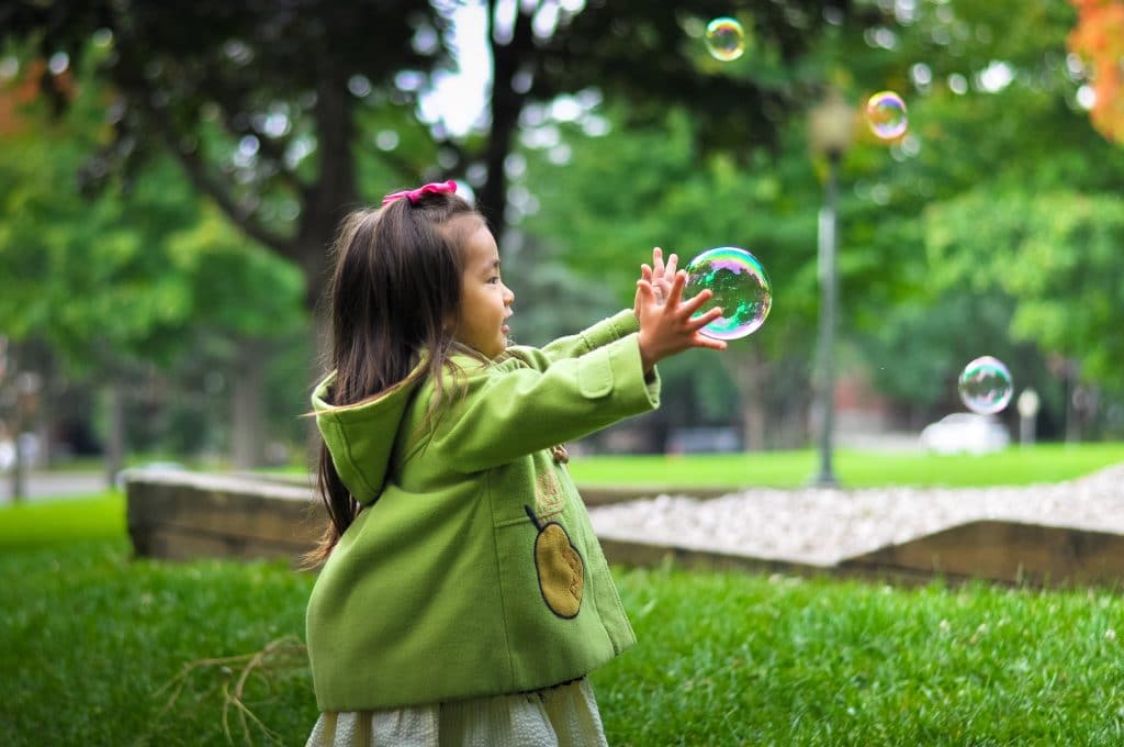Criança brincando com bolha de sabão