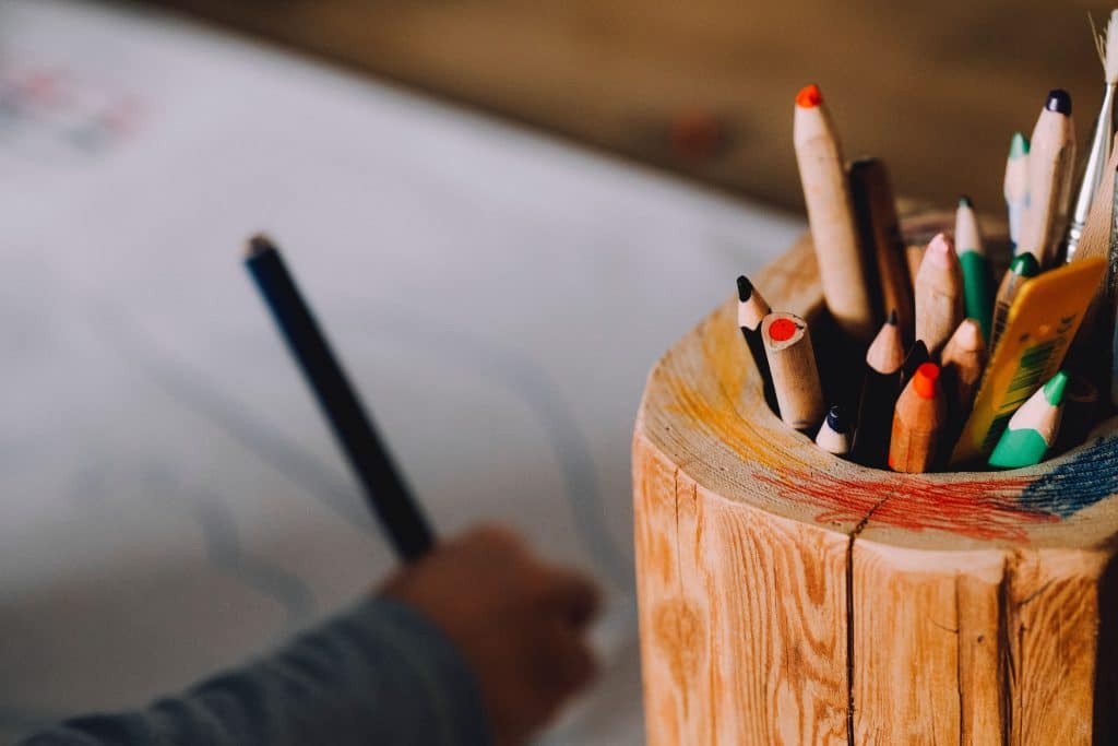 Criança desenhando com lápis de colorir