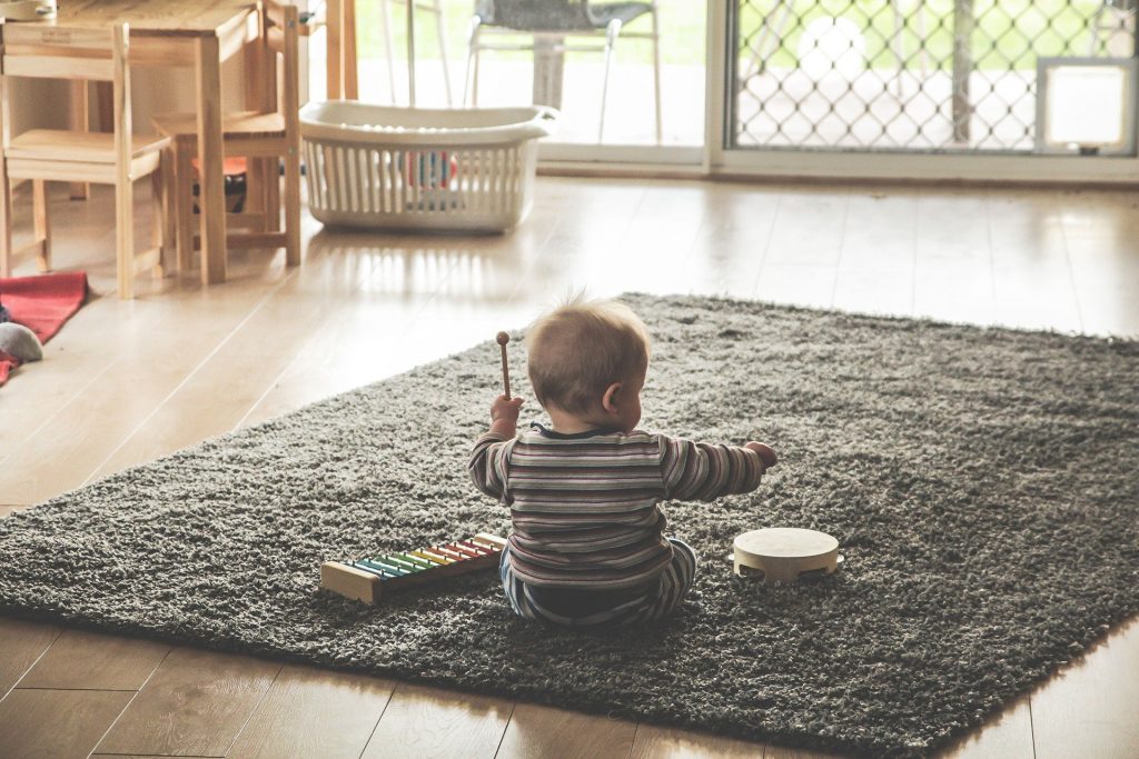 Bebê brincando no tapete da sala