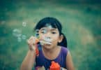 Criança assoprando bolhas de sabão