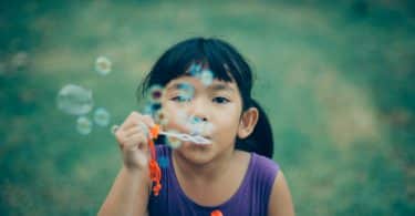 Criança assoprando bolhas de sabão