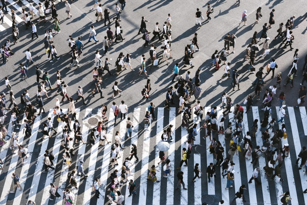 Pessoas atravessando a rua em faixa de pedestre vistas do alto