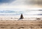 Mulher meditando na praia.
