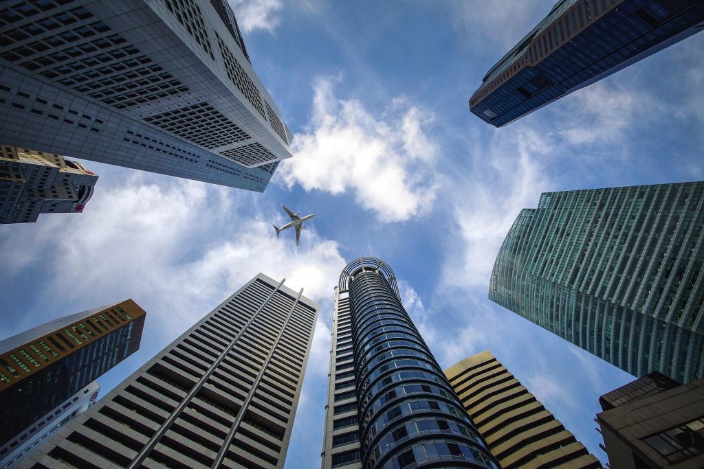 Um avião no centro de um arranha céu - prédios bem altos em uma cidade oriental.