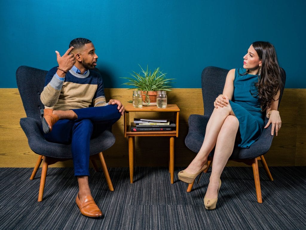 Homem e mulher sentados em poltronas conversando