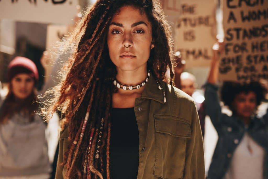 Mulher em frente a um protesto de empoderamento feminino