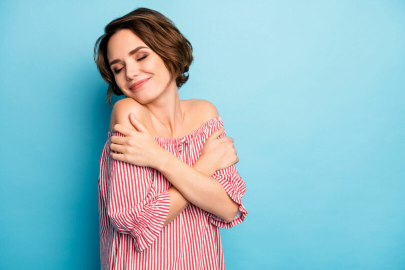 Mulher sorrindo se abraçando