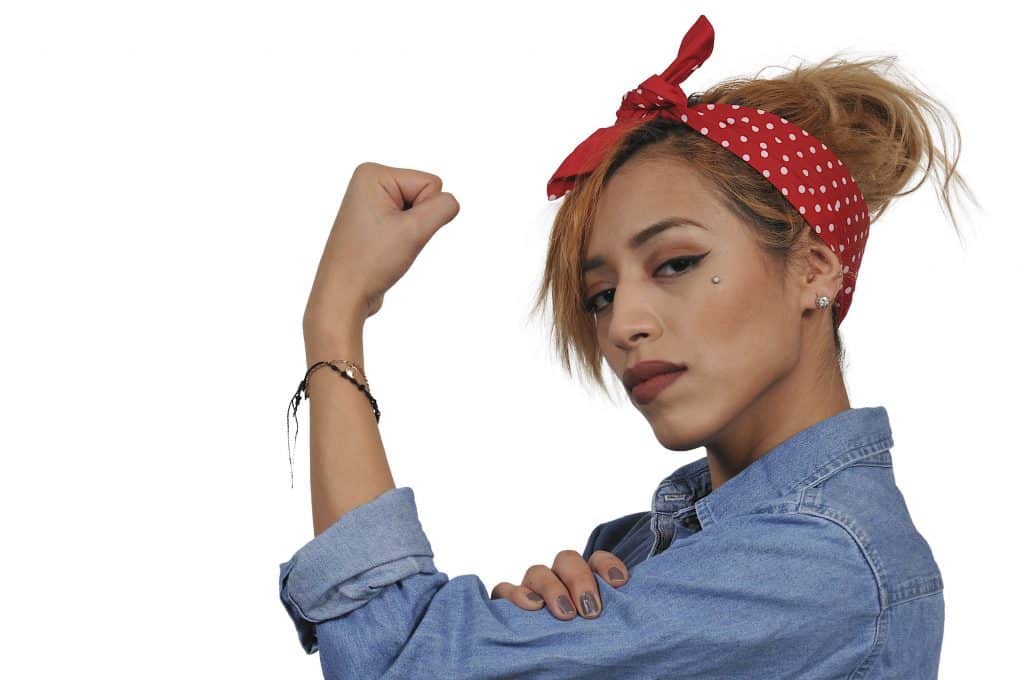 Mulher olhando de lado usando bandana na cabeça e mostrando seu braço forte e seu empoderamento feminino