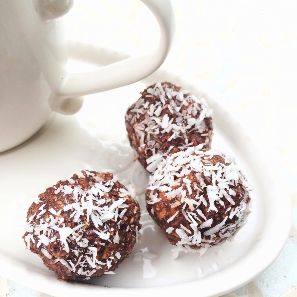 Bolinhas de bolo de chocolate feito na caneca. Eles estão dispostos sobre um prato de porcelana branco.
