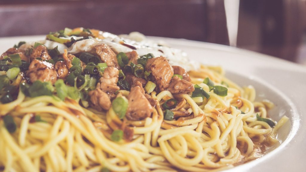 Prato de macarrão espaguetti com frango em pedaços.