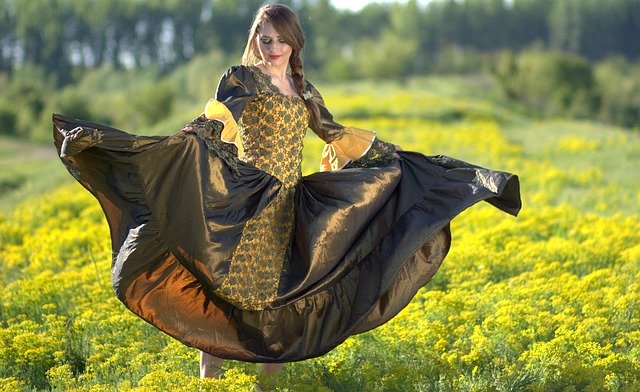 Mulher dançando em grama com vestido de princesa