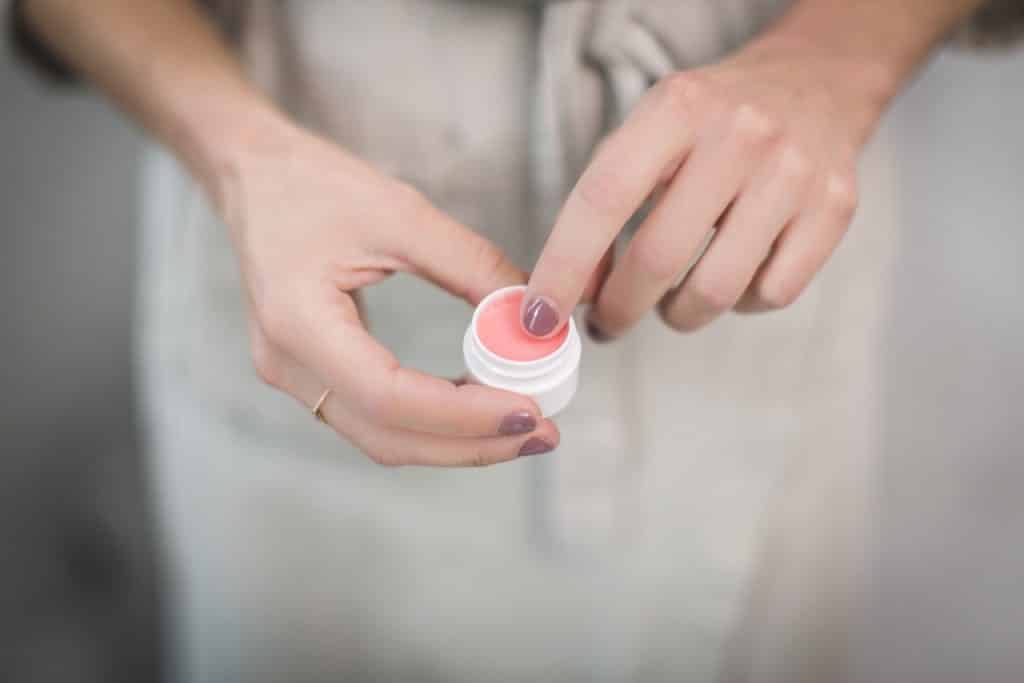 Recorte de uma mulher usando produto para cuidar da pele.
