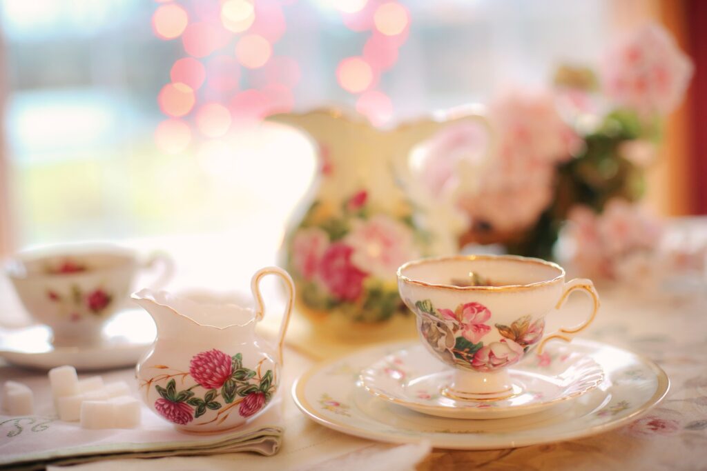 Mesa posta para celebrar a cerimônia do chá que será servido em porcelanas decoradas com flores rosas.