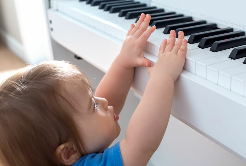 Criança tentando tocar um piano