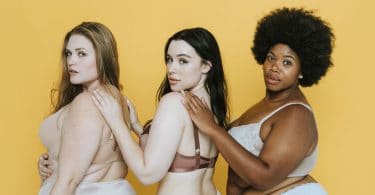 Mulheres de lingerie de costas olhando para trás com fundo amarelo