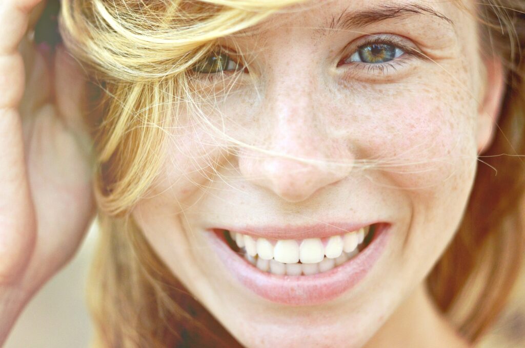 Mulher sorrindo com o cabelo voando em seu rosto