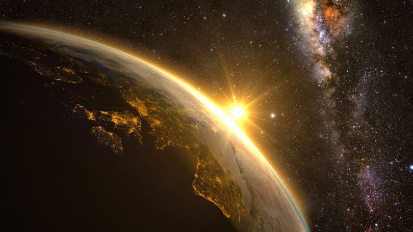 Imagem espacial do planeta Terra, com o sol nascendo no continente europeu.