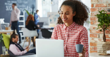 Mulher trabalhando sorrindo em espaço de cowork