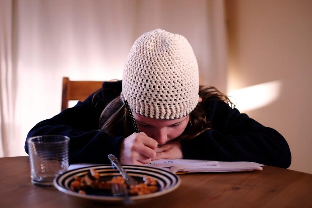 Criança evitando de comer pois está desenhando